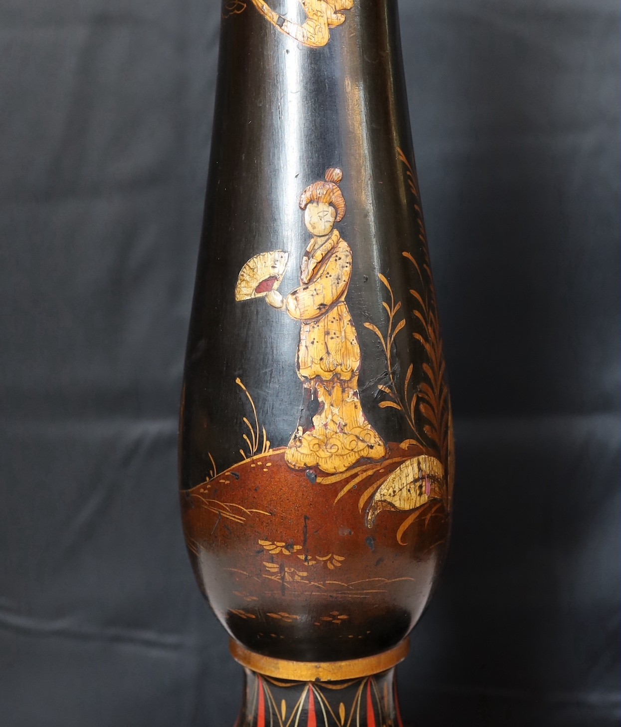 A 1920s English chinoiserie lacquered lamp standard, decorated with gilt figures in boats and flowers on a black ground, height 164cm. width of base 38cm